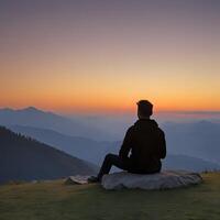 ein Mann Sitzung im Vorderseite von ein Berg beim Sonnenuntergang foto