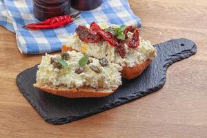 Bruschetta mit Weichkäse, Kapern und Tomate foto