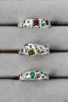elegant Silber Ringe geschmückt mit atemberaubend Edelsteine auf Weiß Hintergrund, Luxus Schmuck Sammlung. foto