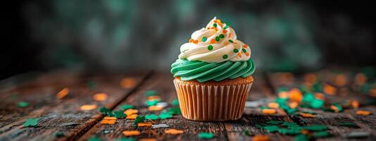 beschwingt Cupcake mit Orange und Grün Glasur, dekoriert zum st. Patrick's Tag auf ein hölzern Hintergrund foto