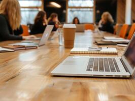 Laptop auf hölzern Tabelle mit Geschäft Treffen im verschwommen Hintergrund foto