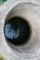 oben Aussicht tief lokal Wasser Gut mit Betrachtung auf Grün Wasser foto