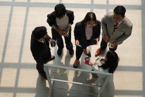 Business-Team mit Kaukasiern und Asiaten arbeiten im Büro zusammen foto