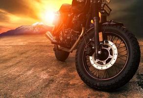 altes Retro-Motorrad und schöner Sonnenunterganghimmelhintergrund foto