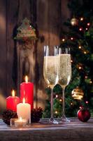 Nahaufnahme von zwei Gläsern mit Champagner und Kerzen auf der Farbrückseite foto