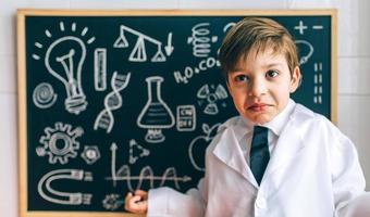 Kind verkleidet als Wissenschaftler und Tafel foto