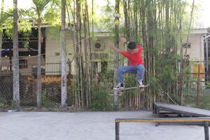 Indonesien - - medan 17 August 2023 ein asiatisch Mann tun Skateboard Tricks auf ein Rampe foto