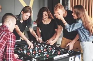 Freunde spielen zusammen Brettspiele, Tischfußball foto