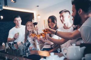 Freizeit- und Kommunikationskonzept. Gruppe glücklicher lächelnder Freunde, die Getränke genießen und sich in der Bar oder im Pub unterhalten foto