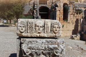 historisch Stein Basrelief mit geschnitzt Gesichter im uralt Stadt von Myra. Ruinen von Felsenschnitt Gräber im Lykien Region, demre, Antalya, turkiye foto