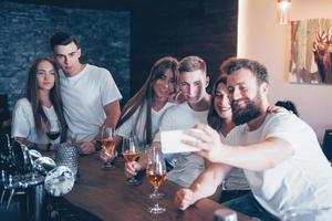 Freizeit- und Kommunikationskonzept. Gruppe glücklicher lächelnder Freunde, die Getränke genießen und sich in der Bar oder im Pub unterhalten foto