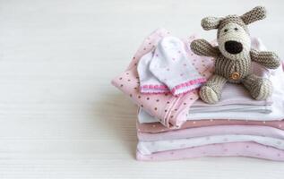 Stapel von Baby Kleidung, Socken und gestrickt Spielzeug foto