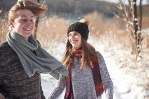 glückliches junges Paar im Winterpark, das Spaß hat. Familie im Freien foto