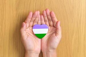 queer Stolz Tag und lgbt Stolz Monat Konzept. Hand halten lila, Weiß und Grün Herz gestalten zum lesbisch, Fröhlich, bisexuell, Transgender, Genderqueer und pansexuell Gemeinschaft foto