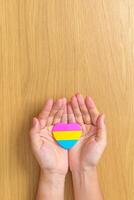 pansexuell Stolz Tag und lgbt Stolz Monat Konzept. Hand halten Rosa, Gelb und Blau Herz gestalten zum lesbisch, Fröhlich, bisexuell, Transgender, queer und pansexuell Gemeinschaft foto