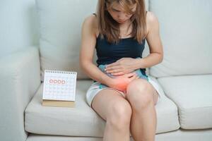 Menstruation Zeitraum Zyklus von monatlich und Magenschmerzen Konzepte. Frau haben Abdomen Schmerzen mit heiß Wasser Flasche und Kalender, Krankheit weiblich leiden von prämenstruell schmerzen und Körper Gesundheit Problem foto