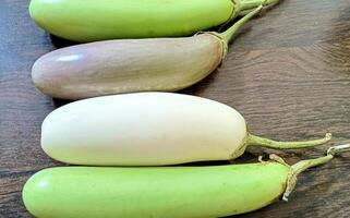 Nahansicht von organisch Weiß und Grün frisch Aubergine oder Aubergine isoliert auf hölzern Hintergrund foto