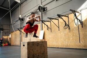 Frau Springen auf ein Box im ein Kreuz Ausbildung Fitnessstudio foto