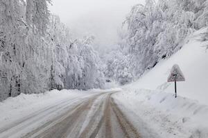 Fahren im das Winter auf eisig Straßen während Winter. Vorsichtig Fahren im Winter Bedingungen. gefroren und rutschig Straßen. Vorsichtsmaßnahmen während Fahren. Rau Wetter. foto