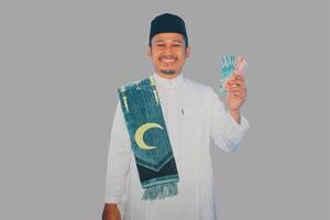 asiatisch Moslem Mann lächelnd glücklich während zeigen Papier Geld foto