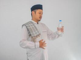 Moslem asiatisch Mann zeigen erleichtert Ausdruck nach trinken ein Wasser foto