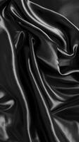 kompliziert Falten und Konturen von glänzend schwarz Stoff bilden hypnotisch Muster, Aufschlussreich das skulptural Qualitäten von das üppig Textil. foto