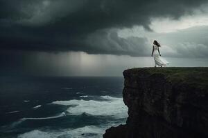 ein Frau im ein Weiß Kleid steht auf das Kante von ein Cliff mit Blick auf das Ozean foto