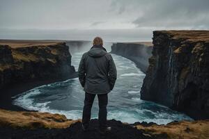 Mann Stehen auf das Kante von ein Cliff suchen beim das Ozean foto