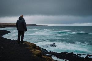 Mann Stehen auf oben von ein Berg im Island foto