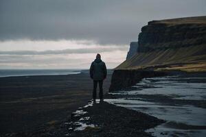 Mann Stehen auf das Kante von ein Cliff mit Blick auf das Ozean foto