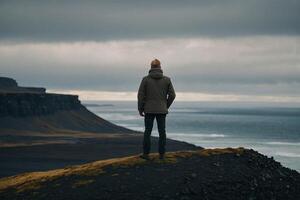 Mann Stehen auf das Kante von ein Cliff mit Blick auf das irisch Landschaft foto