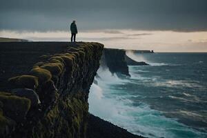 Mann Stehen auf das Kante von das Cliff suchen beim das Ozean foto