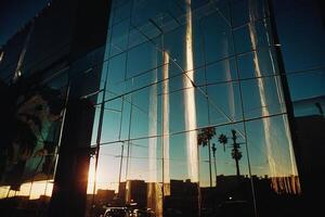 ein Gebäude mit ein groß Glas Mauer und ein Sonnenuntergang foto