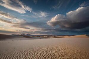 ein Wüste mit Sand Dünen und Wolken beim Sonnenuntergang foto