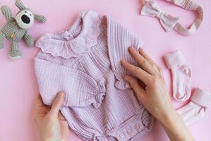 Rosa Bodysuit mit Spielzeug gestrickt Hund, Socken und Stirnband. foto