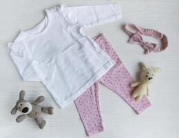 einstellen von Baby Bodys, Hose, Socken und gestrickt Spielzeug foto