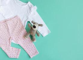 einstellen von Baby Bodys, Hose, Socken und gestrickt Spielzeug foto