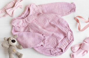 Rosa gestrickt Bodysuit mit Spielzeug gestrickt Hund, Socken und Stirnband. foto