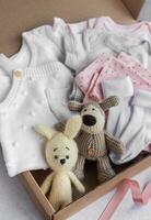 Baby und Kind Kleider und gestrickt Spielzeuge im Karton Kasten. foto