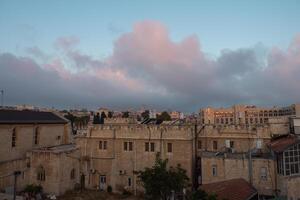 früh Morgen im das Jerusalem. Sonnenaufgang Zeit. Stadt Sicht. alt Gebäude. Wolken auf das Himmel foto