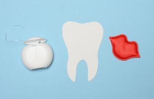 Dental Zahnseide und Papier Zahn auf Blau Hintergrund foto