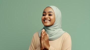 afrikanisch Frau tragen Schal ist beten und lächelnd auf Grün Hintergrund foto