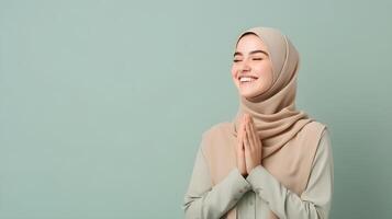 europäisch Frau tragen Schal ist beten und lächelnd auf Grün Hintergrund foto