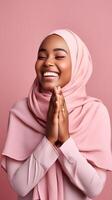 afrikanisch Frau tragen Schal ist beten und lächelnd auf Rosa Hintergrund foto