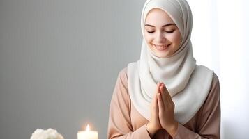 europäisch Frau tragen Schal ist beten und lächelnd auf grau Hintergrund foto
