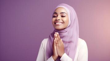 afrikanisch Frau tragen Schal ist beten und lächelnd auf lila Hintergrund foto
