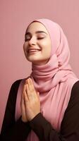 europäisch Frau tragen Schal ist beten und lächelnd auf Rosa Hintergrund foto