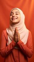 Arabisch Frau tragen Schal ist beten und lächelnd auf rot Hintergrund foto