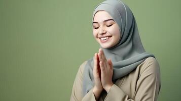 europäisch Frau tragen Schal ist beten und lächelnd auf Grün Hintergrund foto