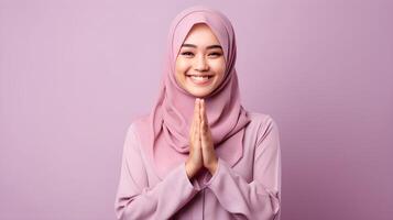 Süd-Ost asiatisch Frau tragen Schal ist beten und lächelnd auf lila Hintergrund foto
